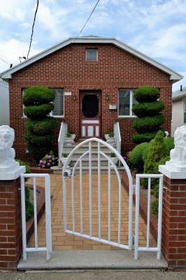 nice brick house with a white gate in front of it